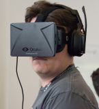 Palmer Luckey wearing Oculus Rift DK1 at SVVR 2014; the headphones are separate.